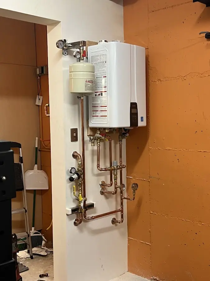 Plumbing technician inspecting water heater connections in Murphy